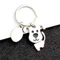 Detailed close-up of a glossy silver metal puppy keychain with a blank oval engraving tag - Movable Dog Style