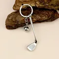 Detailed close-up of a silver golf club keychain with a mini ball on a rustic bark background - Golf Ball & Club Style (A-073 Golf)