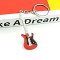 Close-up of red and black enamel electric guitar keychain with detailed metal tuning pegs - Red