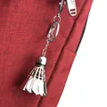 Kreativer Federball-Schlüsselanhänger aus Silbermetall auf rotem Stoffhintergrund - Large Shuttlecock with Lobster Clasp / Silber