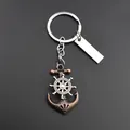 Macro view of vintage bronze anchor keychain with spinning silver ship wheel detail - With Rectangular Tag / Copper