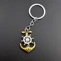Detailed close-up of a vintage nautical keychain with a bronze anchor and spinning helm wheel - No Tag Style / Bronze