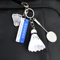 Portachiavi con racchetta e volano da badminton appeso su uno zaino nero testurizzato - Volano Bianco e Racchetta Grande in Lega Stile Segnale Stradale