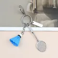 Dettaglio del portachiavi con volano da badminton blu e racchetta in metallo argento - Racchetta da Badminton Con Volano Blu Chiusura a Moschettone E Targhetta Rettangolare