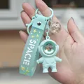 Light blue astronaut keychain with SPACE strap and bell charm held in hand - Sunset Lamp Astronaut-Blue