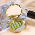Specchio da trucco rotondo dorato lucido a doppia faccia pieghevole su sfondo elegante - Oro
