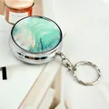 Close-up of portable metal ashtray with green marble pattern and silver keychain detail - Keychain style / Green Marble (Vienna)