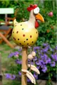 Close-up of yellow resin chicken garden ornament with polka dots on a wooden stake - Yellow