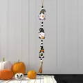 Halloween gnome wooden bead garland with wizard hats, pumpkin, and tassels hanging on wall - Three Gnomes Style