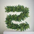 Dettaglio della ghirlanda natalizia in aghi di pino PVC per decorazione d'interni - Rattan da 180CM