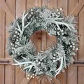 Frosted Weihnachtskranz mit weißen Geweihen und Zapfen an einer rustikalen Holztür - 50cm / Geweih-Kranz