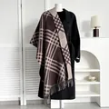 Detailed view of the brown plaid scarf with fringe paired with a black winter coat - Diagonal Stripe Coffee