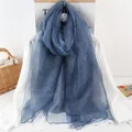 Texture détaillée de l'écharpe en soie bleu marine sur chemise blanche avec décor de camélia - 190x70 / Bleu Marine
