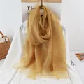 Gros plan d'une écharpe en soie jaune moutarde légère et brillante sur une chemise - 190x70 / Curcuma
