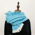 Detail view of a thick blue and white plaid scarf featuring elegant white fringe edges - 190cm / Lake Blue