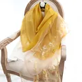 Elegant bright yellow silk wool shawl featuring delicate floral embroidery on wood chair - 180x80cm / Turmeric