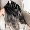 Detail of floral embroidery on black silk wool scarf with metallic edges on a leather chair - 195CM / Elegant Black