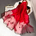 Détail d'une écharpe en soie rouge foncé avec broderies et bords en fil d'argent - 195CM / Rouge