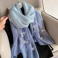 Elegante bufanda de seda y lana degradada con bordado floral y accesorio de camelia - Azul Denim Degradado
