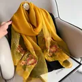 Detail of floral embroidery on lightweight golden silk wool scarf with intricate patterns - 195CM / Yellow
