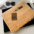 Elegant camel faux cashmere scarf with tassels, leather label, and luxury lifestyle props - Bright yellow