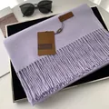 Lavender faux cashmere scarf with fringe details folded on a black tray - Lilac Purple