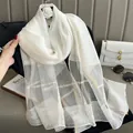 Detailed view of white silk mohair scarf with golden thread and woven grid texture - White