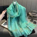 Détail d'une écharpe en soie vert clair avec des rayures dorées et texture légère - 195CM / Vert