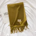 Close-up of olive green cashmere-feel scarf with fringe edges and brand textile label - Army Green