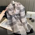 Detail of silk plaid scarf showing light pink texture with black stripes and gold thread - Pink