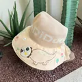 Macro shot of a beige sun hat featuring cartoon dinosaur prints and mesh texture - Khaki