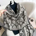 Dettaglio della sciarpa in finto cashmere con motivo floreale e bordo a righe - Nero e Bianco