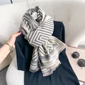 Detailed view of maze pattern jacquard scarf with short fringe on textured white sofa - 196cm / Light Gray