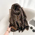 Close-up of thick maze pattern scarf with detailed fringe edges on a white textured background - 196cm / Black Camel