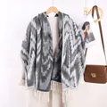 Close-up of zigzag patterned cashmere scarf with tassel fringe on a wool coat - Gray