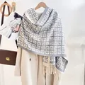 Close-up of geometric knit scarf with fringe trim paired with a stylish wool coat - Gray