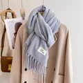 Close-up of light blue scarf with soft texture, fine fringes and stylish woven label - Light Gray