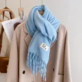 Detail of light blue knitted scarf featuring long tassel fringe and soft wool-like texture - Azure Blue