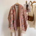 Bohemian paisley core-spun yarn scarf with tassels draped over a beige coat - Maya Pattern Beige