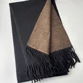 Detail view of double-sided wool scarf showing solid black and brown fabric with long tassels - Black Coffee