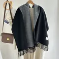 Detail of wool blend scarf with fringe edges and rectangular label on white wall - Black and Gray