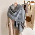 Detail of gray plaid scarf with cat patterns and tassels styled on a wool coat - Cat-Grey