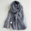 Détail d'une écharpe en soie plissée gris anthracite avec texture semi-transparente et bords ondulés - Bleu Marine