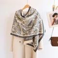 Detail eines Pashmina-Schals mit Stadtmuster hängend am Mantel mit Fransen - Grau