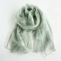 Détail d'une écharpe en soie vert clair semi-transparente avec brillance et texture douce - Vert Cyan