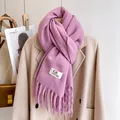 Thick purple knit scarf with fringes and woven label on a minimalist beige coat display - Light Purple
