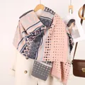 Dettaglio dello scialle etnico rosa e grigio con nappe e motivi geometrici su un cappotto - Stile Pois Maya Rosa