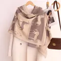 Détail d'une écharpe imitation cachemire avec motif cheval et franges sur cintre - Khaki