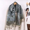 Sciarpa blu con motivo floreale paisley e nappe appesa su un cappotto beige - Blu Denim