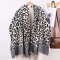 Elegante sjaal met luipaardprint, strepen en franjes op een beige lange winterjas - Zwarte Luipaardprint